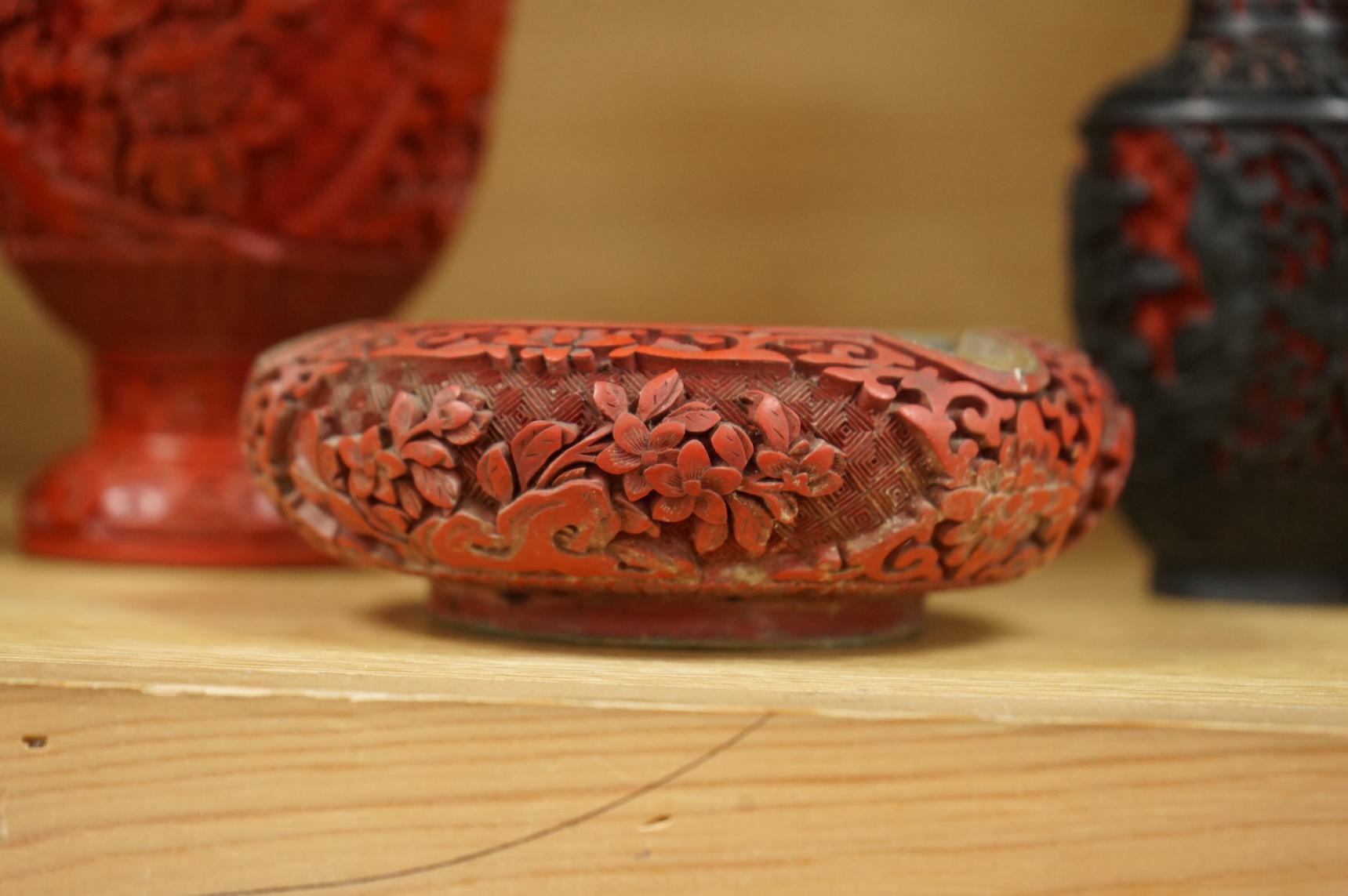 Two Chinese cinnabar lacquer vases and an ashtray, largest 20cm high